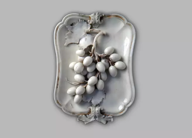Porcelāna palāta ar vīnogu ķekava atveidu uz tās.