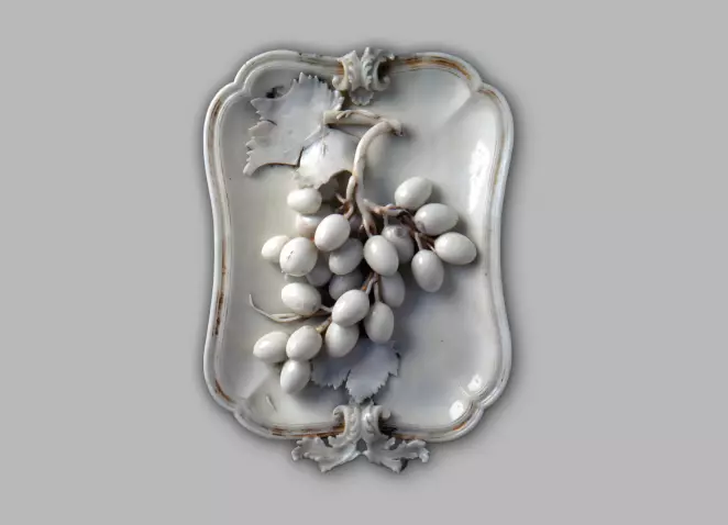 Porcelāna palāta ar vīnogu ķekava atveidu uz tās.