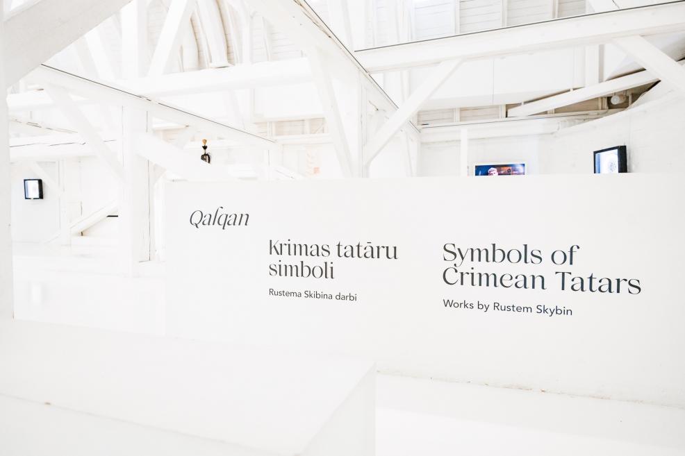 Izstādes “Qalqan. Krimas tatāru simboli” ievada siena ar nosaukumu latviešu un angļu valodā.