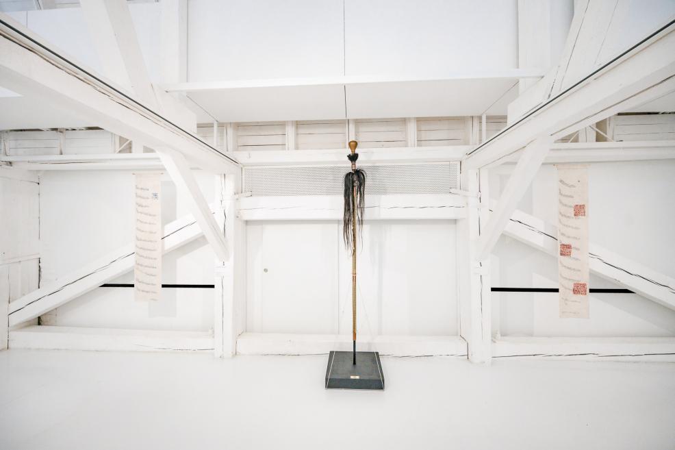 Blue Crimean Tatar flag hanging in a white wooden attic-like exhibition space.