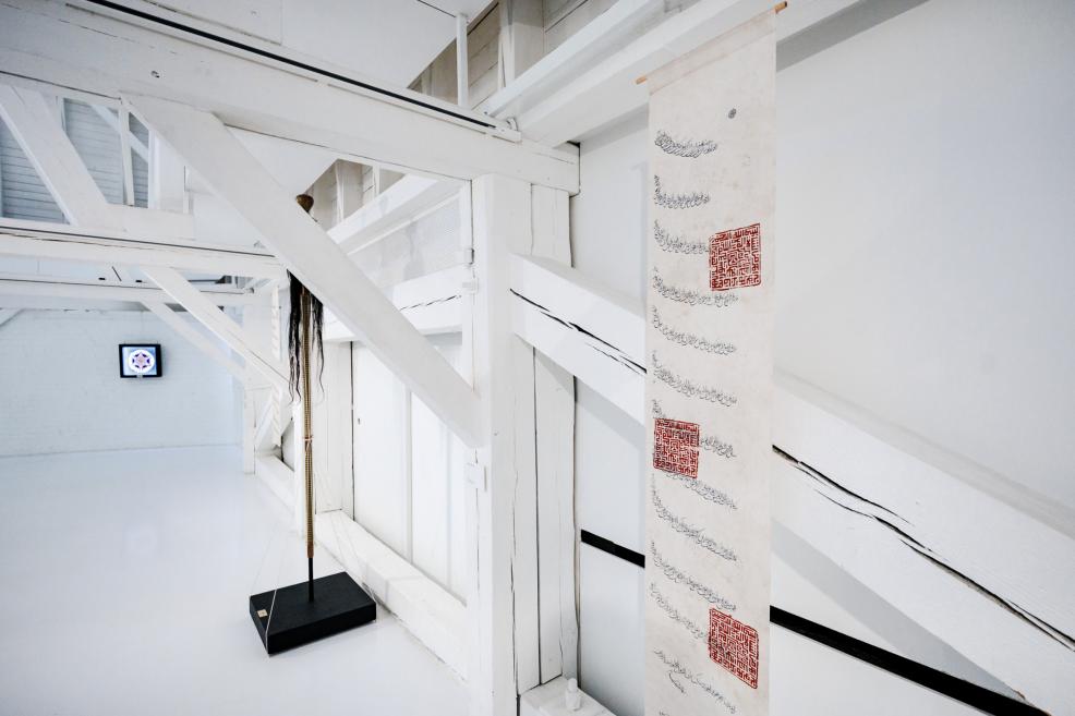 Exhibition title wall reading “Qalqan. Symbols of Crimean Tatars” in a bright white gallery.