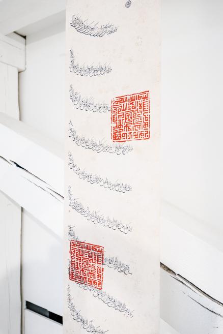 Exhibition title wall reading “Qalqan. Symbols of Crimean Tatars” in a bright white gallery.