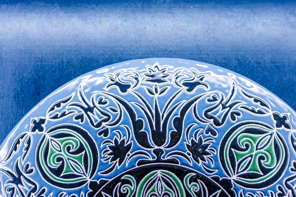 Fragment of a decorative plate surface with floral and symbolic ornament in blue and green from the exhibition “Qalqan. Symbols of Crimean Tatars”.