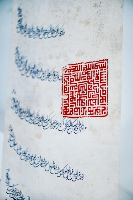 Document featuring Arabic calligraphy and a red square seal from the exhibition “Qalqan. Symbols of Crimean Tatars”.