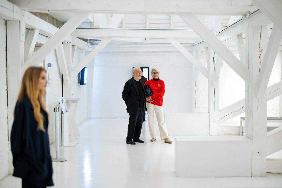 Izstādesatklāšanas viesi aplūko eksponātus gaišajā Kupola zālē.