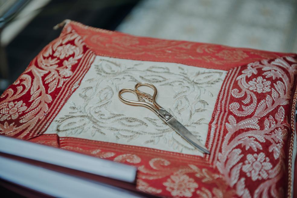 Golden scissors placed on a decorative cushion before the ribbon-cutting ceremony.