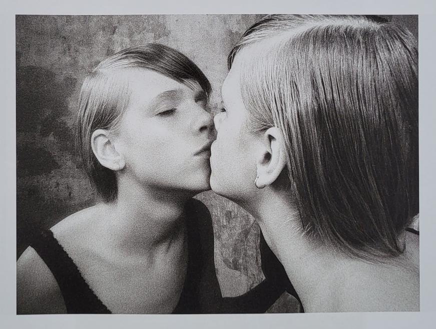 Black and white photo of a woman in a kiss.