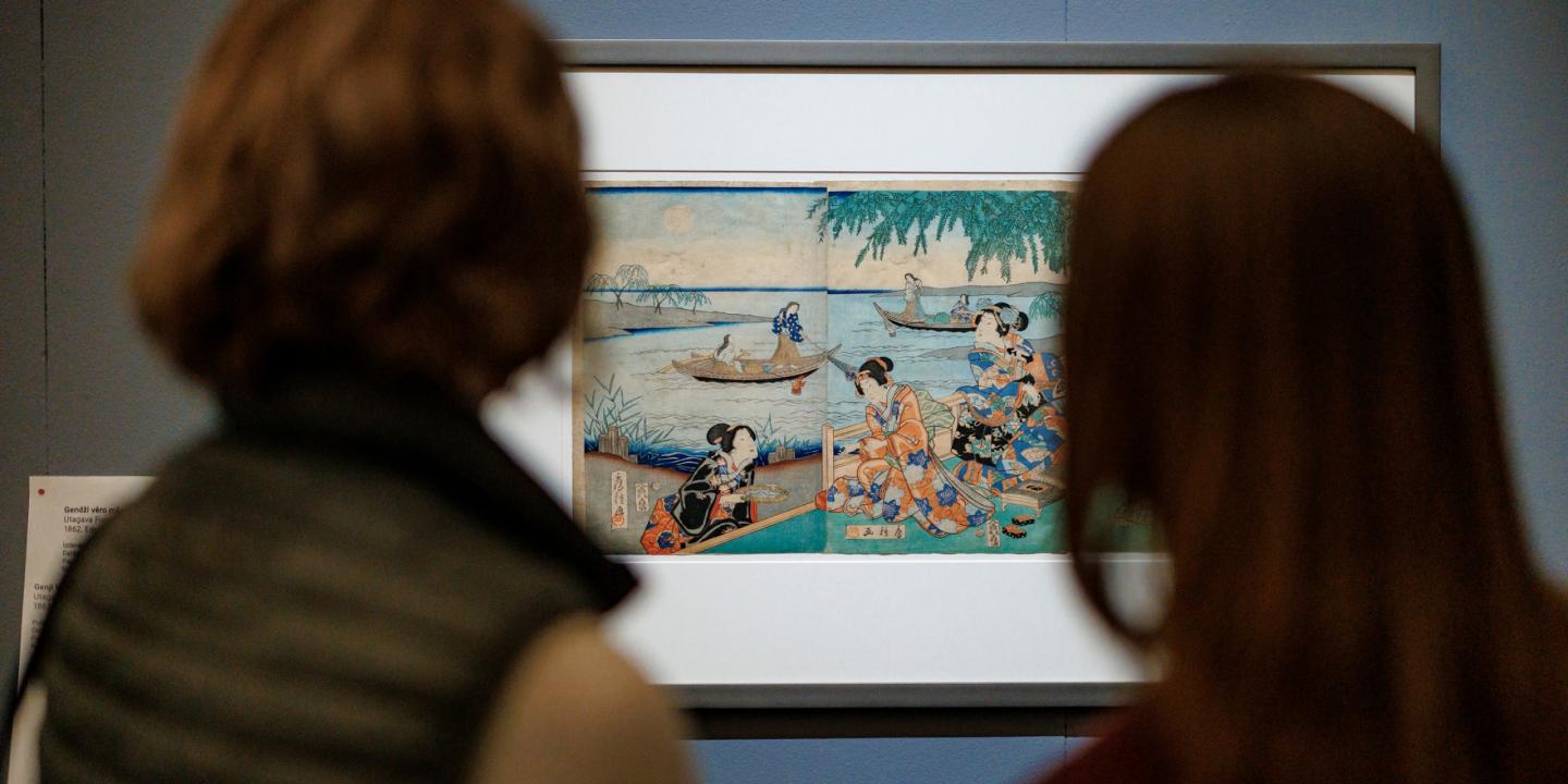 Divi apmeklētāji skatās japāņu grafikas darbu muzeja ekspozīcijā.