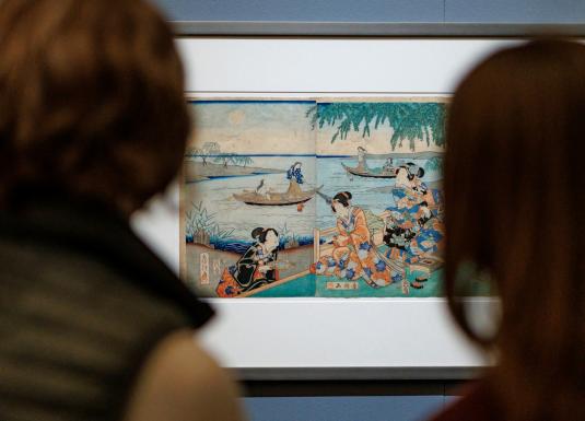 Divi apmeklētāji skatās japāņu grafikas darbu muzeja ekspozīcijā.