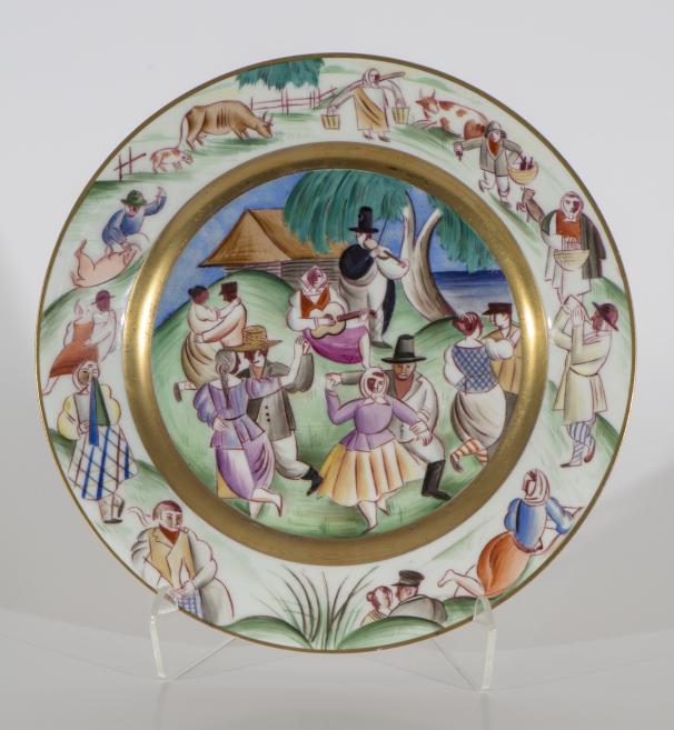 Porcelain plate with a painted rural dance and music scene, showing people and animals in a circular composition.