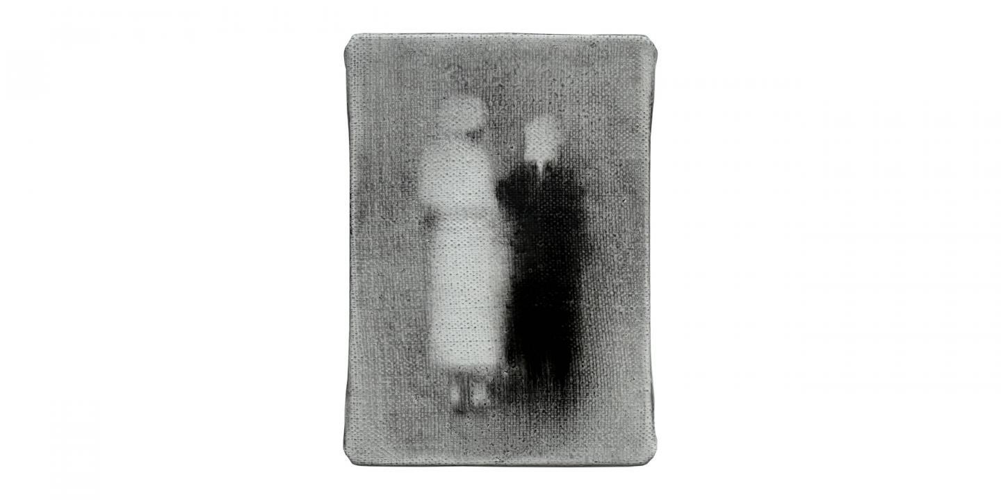 In a small grey-toned image, two blurred human figures stand side by side, one lighter and one darker, creating a vague, ghostlike effect.