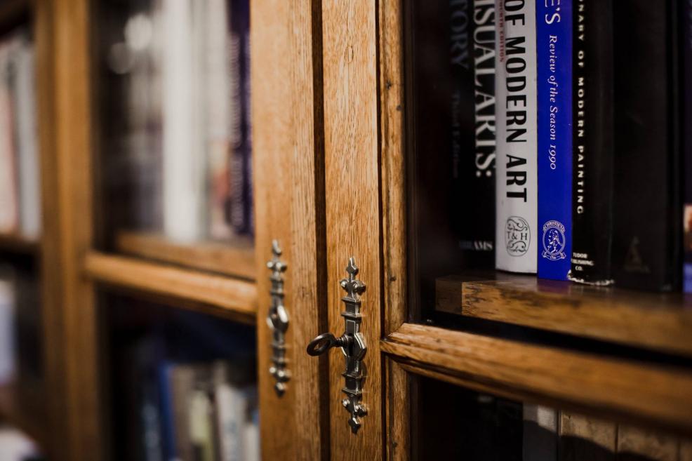 Tuvplāns ar Latvijas Nacionālā mākslas muzeja bibliotēkas grāmatu skapja metāla atslēgām un stikla durvīm.