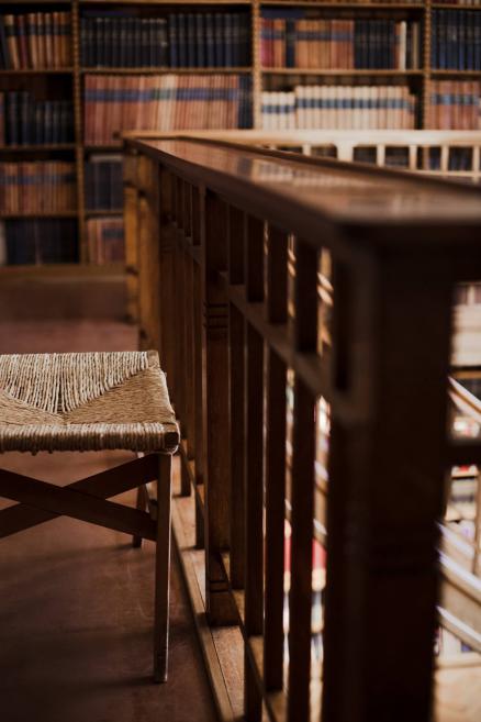 Latvijas Nacionālā mākslas muzeja bibliotēkas balkons ar koka margām un pītu krēslu.