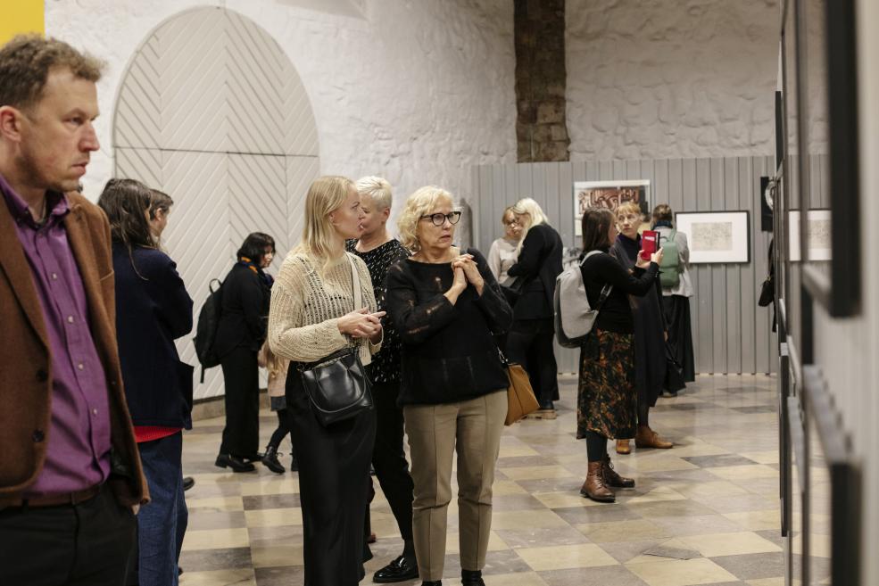 Visitors look at works at the opening of the exhibition.