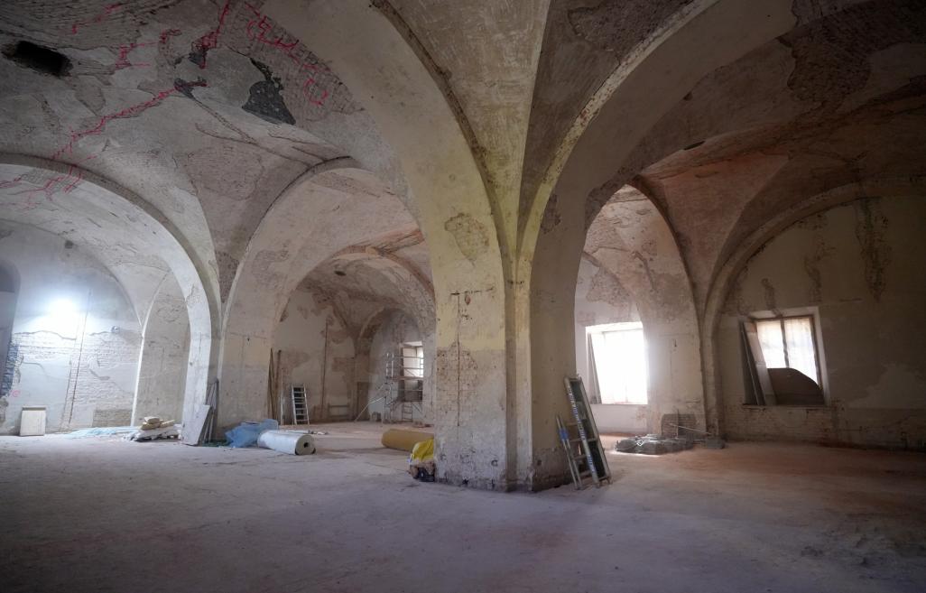Historic interior with exposed brick walls and vaulted ceilings during renovation.