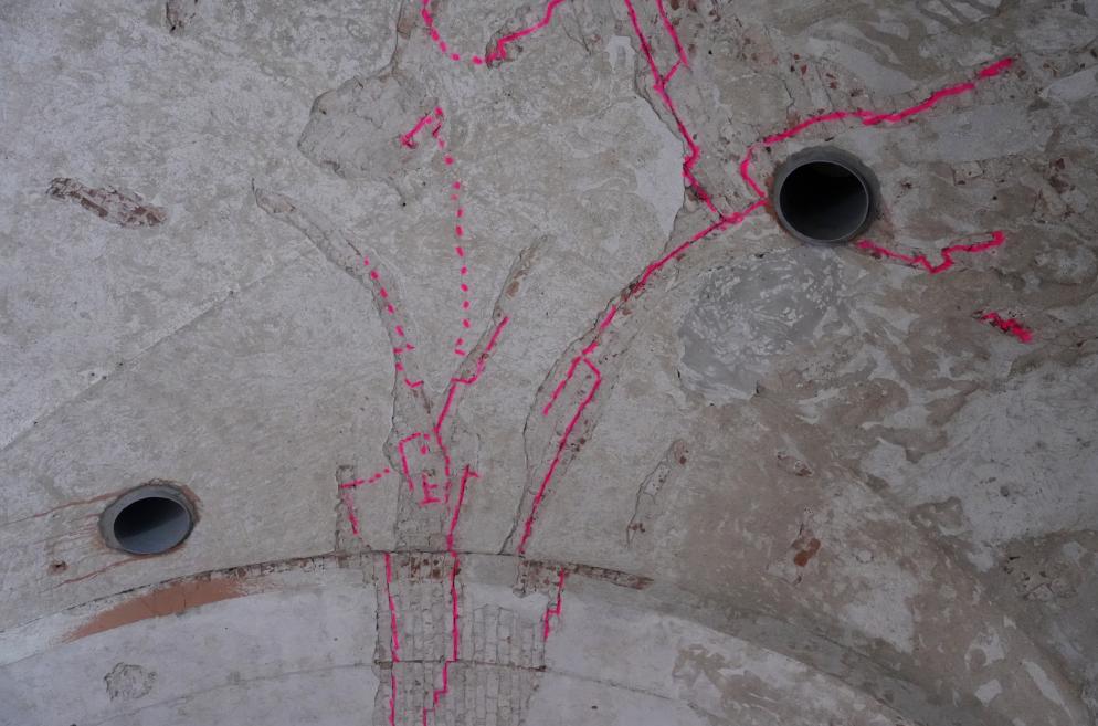 Close-up of ceiling with bright pink markings indicating restoration areas.