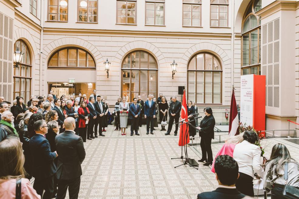 A woman speaks at the microphone during a formal event.