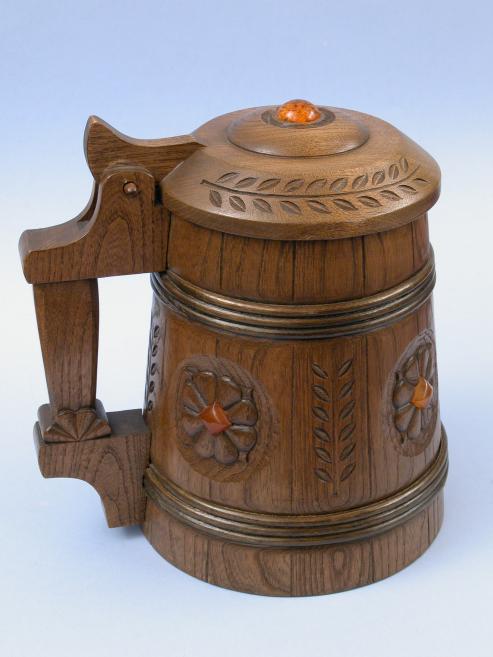 Grebts koka trauks ar rokturi, lapu ornamentiem un dzintara krāsas dekoratīvu pogu uz vāka.