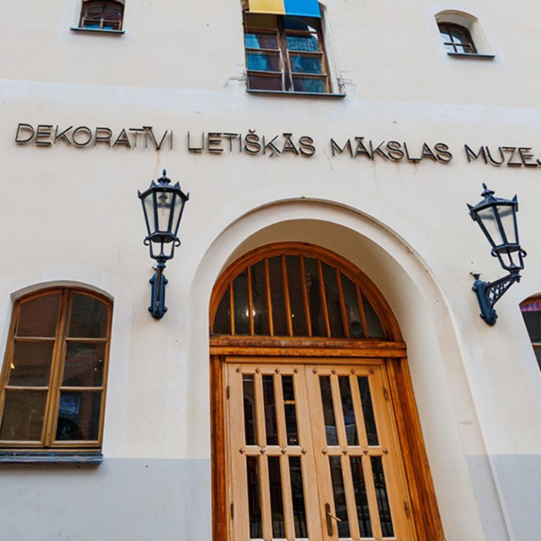 Façade of the Museum of Decorative Arts and Design building in Old Riga with the entrance portal and flags.