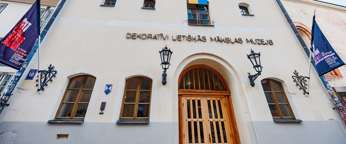 Façade of the Museum of Decorative Arts and Design building in Old Riga with the entrance portal and flags.