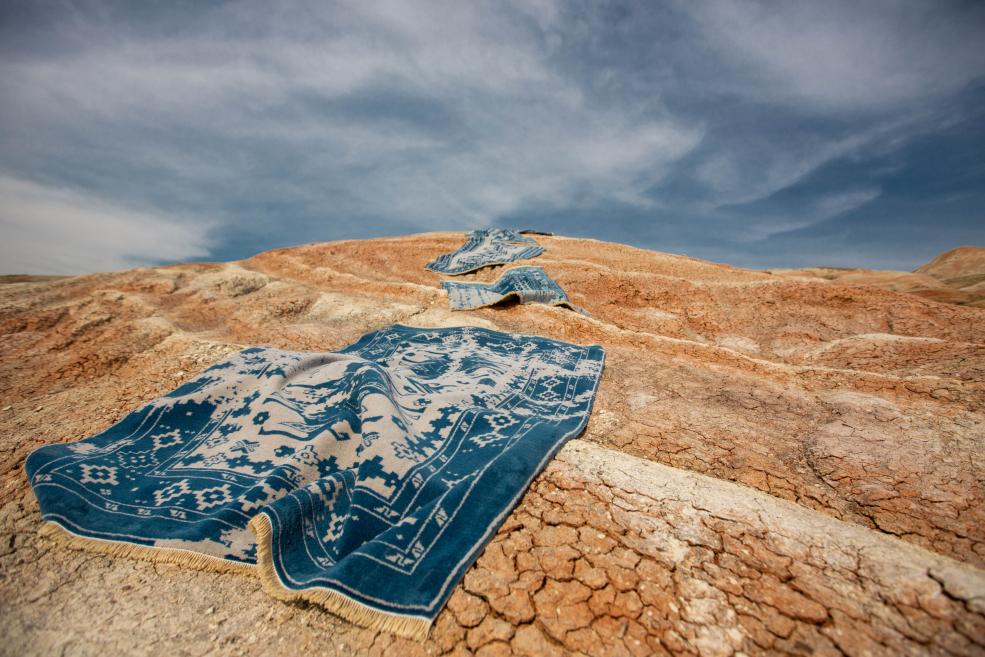 Blue carpets in desert sand.