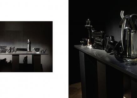 Tumšā ekspozīcijas telpā uz gara postamenta izgaismoti izvietoti melna un caurspīdīga stikla skulpturāli objekti, kas veido vienotu, ritmisku kompozīciju ar izteiktu gaismas un ēnas spēli.