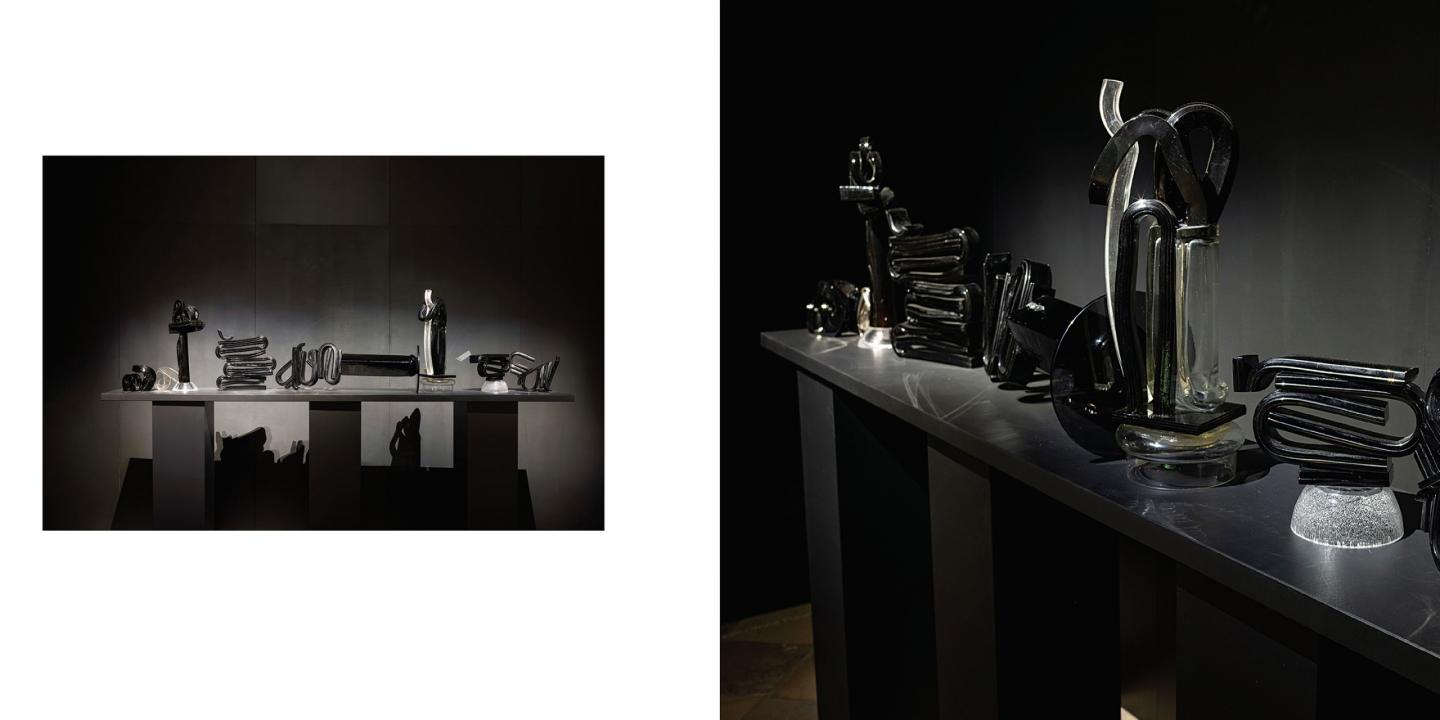 Tumšā ekspozīcijas telpā uz gara postamenta izgaismoti izvietoti melna un caurspīdīga stikla skulpturāli objekti, kas veido vienotu, ritmisku kompozīciju ar izteiktu gaismas un ēnas spēli.