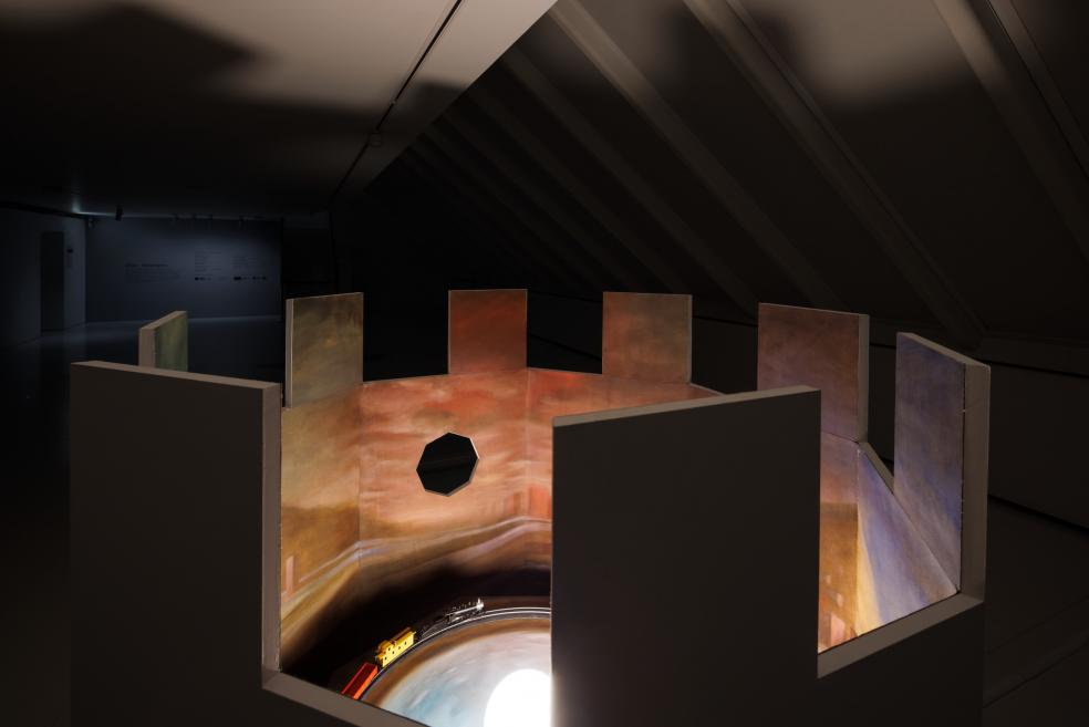 An installation at the exhibition, which is a moving train in a painted landscape