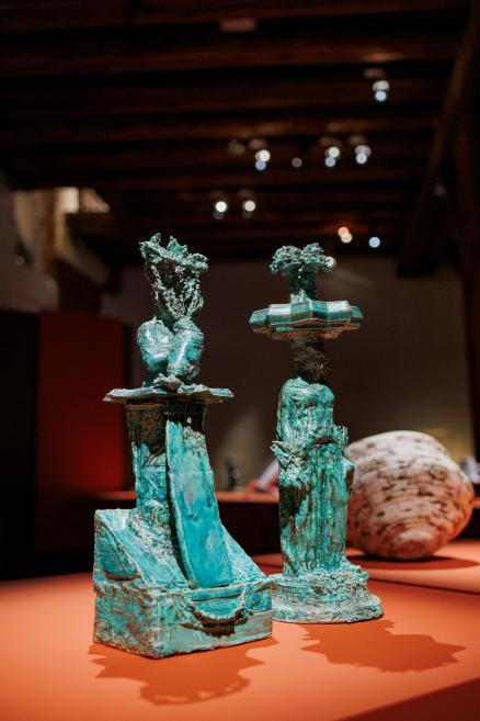 Two green-blue abstract sculptures on an orange plinth in a museum display.