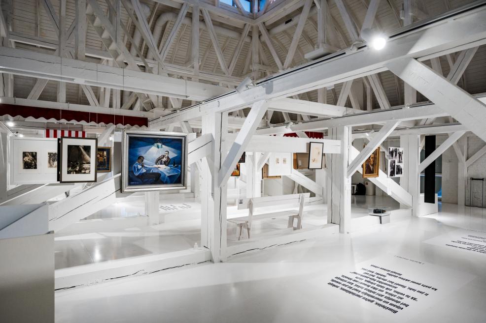 Exhibition overview with paintings and wooden structures.