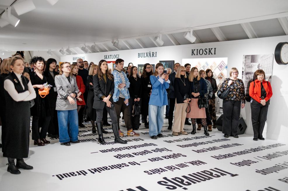 Visitors at an exhibition opening in a museum gallery.