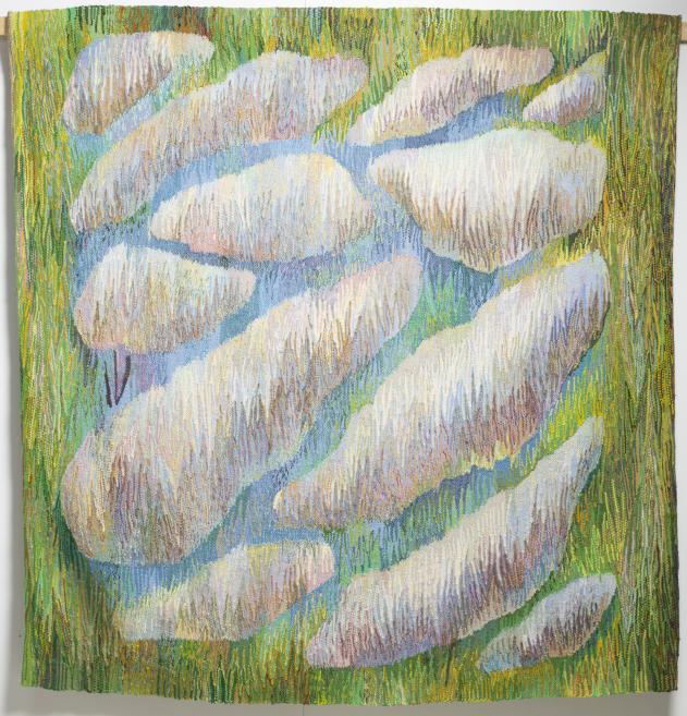 A large tapestry with soft, elongated white cloud-shaped patterns on a blue-green and green background.