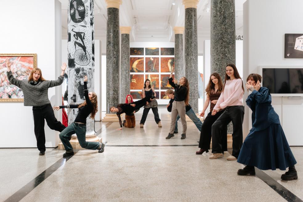 Jaunieši muzeja zālē starp kolonnām kustībā un pozās mijiedarbojas ar laikmetīgās mākslas darbiem.