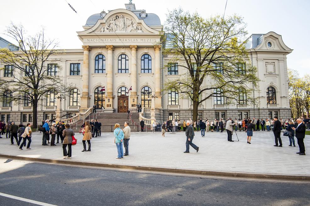 Cilvēki pulcējas pie Latvijas Nacionālā mākslas muzeja galvenās ieejas dienas laikā.