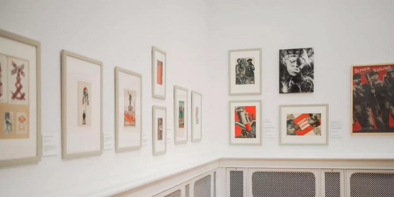 Izstādes siena ar dažādiem konstruktīvistu un dadaisma ietekmētiem kolāžu un fotomontāžu darbiem, kas veidoti sarkanā un melnā toņu gammā.