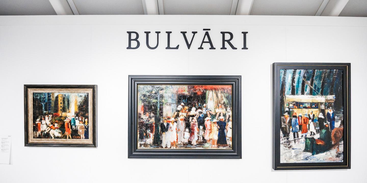 Izstādes siena ar trīs ekspresīvām pilsētas ainavu gleznām zem uzraksta “BULVĀRI”.