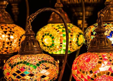 Colorful mosaic lamps with warm light illuminate the dark background, creating an oriental atmosphere.