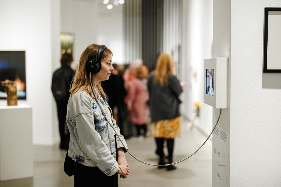 A visitor listens to audio materials at the exhibition.