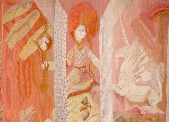 A textile artwork in warm pink and orange tones featuring stylised figures and mythological motifs arranged in decorative panels.