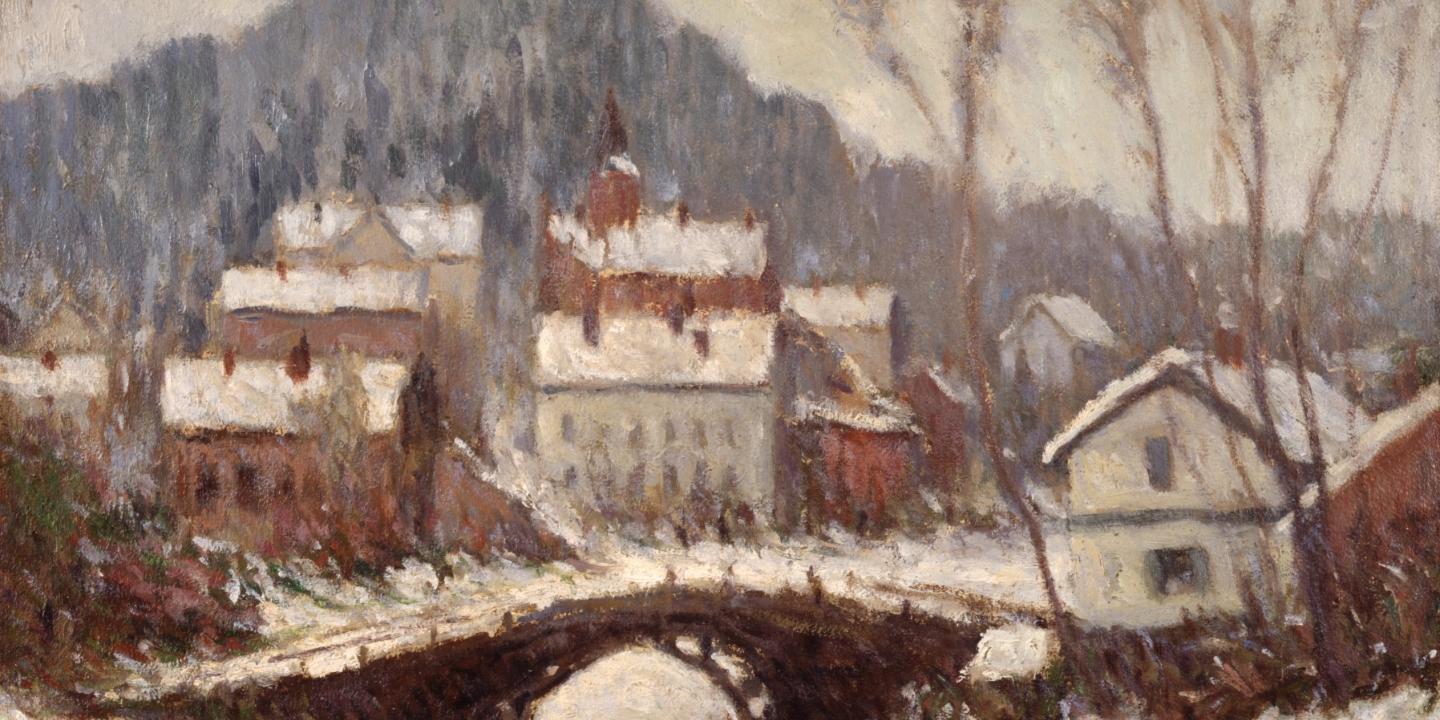 A winter townscape with a bridge over a river and snow-covered houses at the foot of a hill.