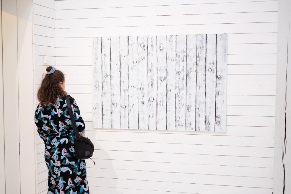 A visitor examines the works of art at the opening of the exhibition.