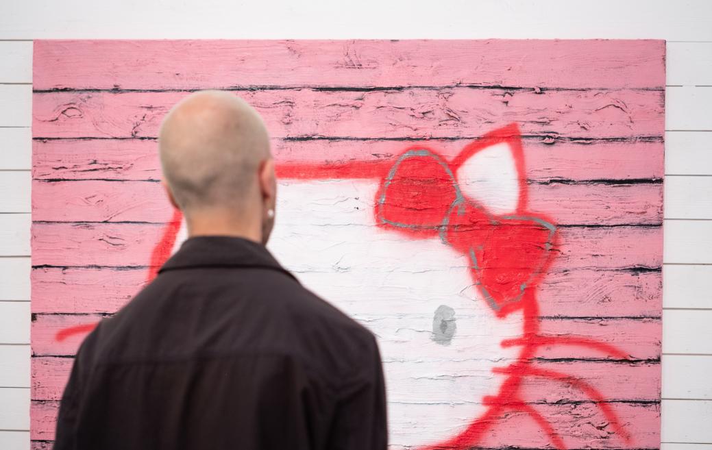 The visitor examines the works of art at the opening of the exhibition.