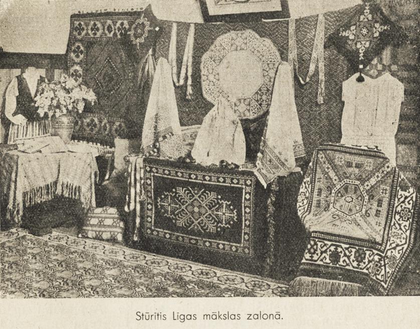 Fotogrāfija attēlo Līgas mākslas salonu ar izstādītiem paklājiem, izšuvumiem un tautas mākslas priekšmetiem.
