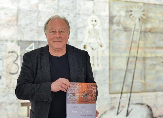 Mākslinieks Imants Tillers ar grāmatu rokās.