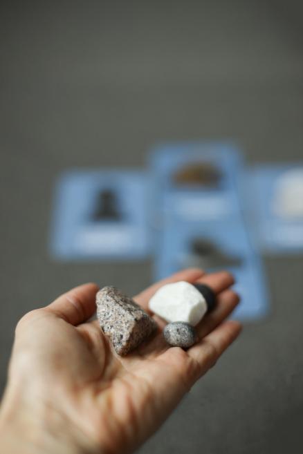 Rokā turēti akmeņi – granīts, marmors un melns akmens.