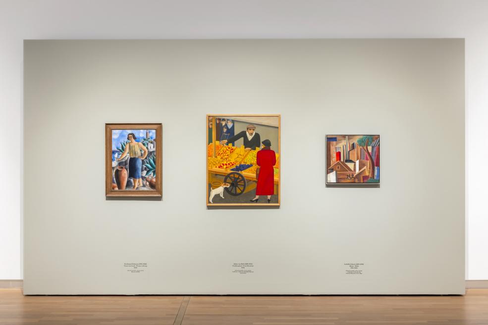 Divi apmeklētāji aplūko modernisma gleznas baltā izstāžu zālē, fonā redzams “European Realities” ekspozīcijas ievads.