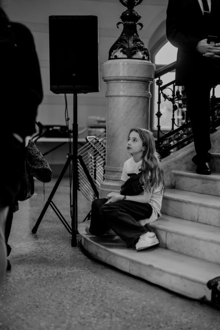 Black and white image with a little girl on stairs.