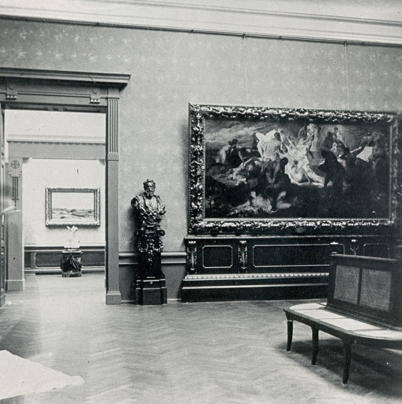 Historic museum gallery interior with a large painting, a sculpture, and a bench for visitors.