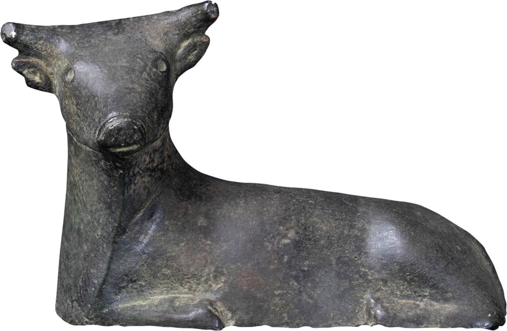 Dark sculpture or ceramic figure with a stylized animal head and массивe body on a white background.