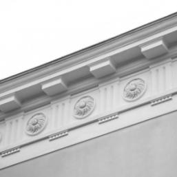 Black and white architectural detail with sun motif reliefs and a cornice.